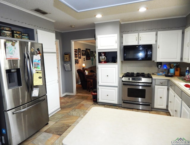 kitchen with appliances with stainless steel finishes, a textured ceiling, white cabinetry, and ornamental molding