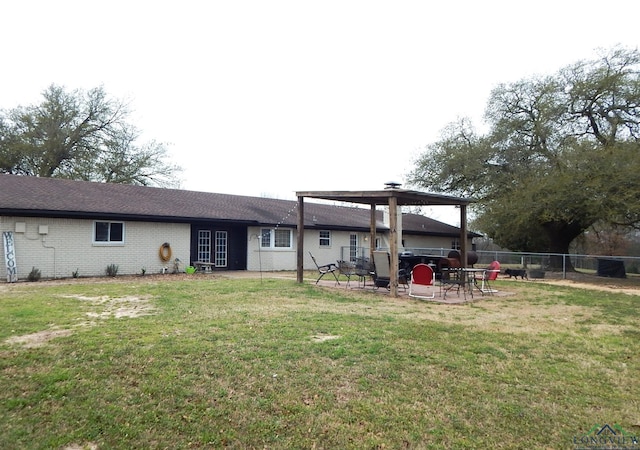 rear view of property featuring a lawn and a patio