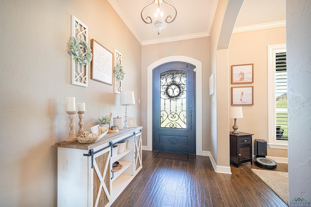 foyer featuring a notable chandelier, dark wood-type flooring, and ornamental molding