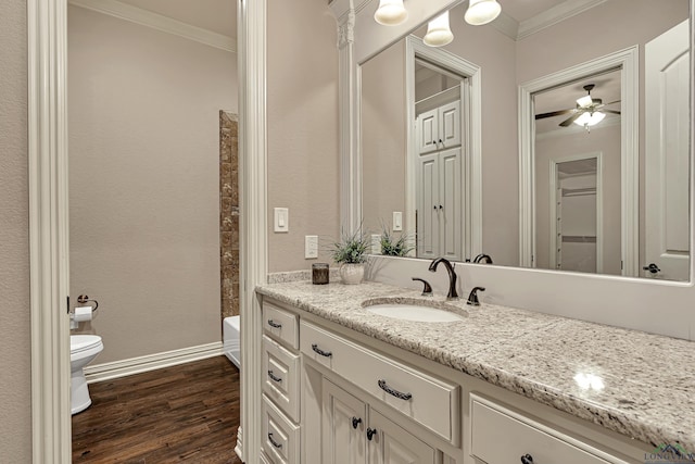 full bathroom featuring toilet, ornamental molding, vanity, wood finished floors, and baseboards