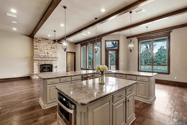 kitchen featuring a large island, visible vents, dark wood-style flooring, and beam ceiling