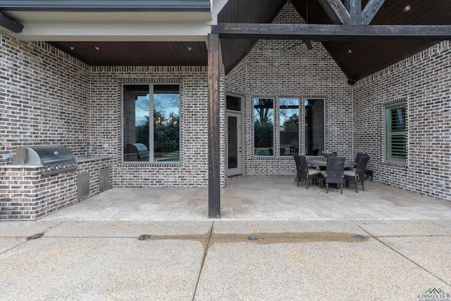 view of patio featuring an outdoor kitchen and a grill