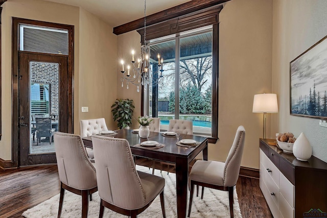 dining room with a notable chandelier, dark wood finished floors, and baseboards