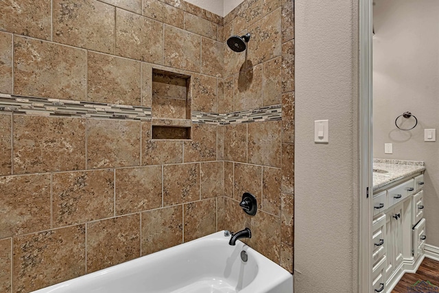 bathroom featuring a textured wall, shower / tub combination, and wood finished floors