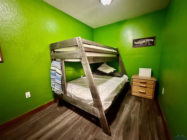 bedroom with dark hardwood / wood-style flooring