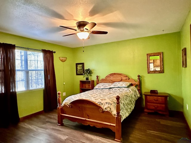 bedroom with dark hardwood / wood-style flooring, a textured ceiling, and ceiling fan