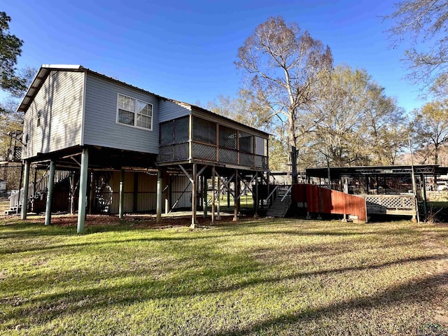 rear view of property featuring a lawn and a sunroom