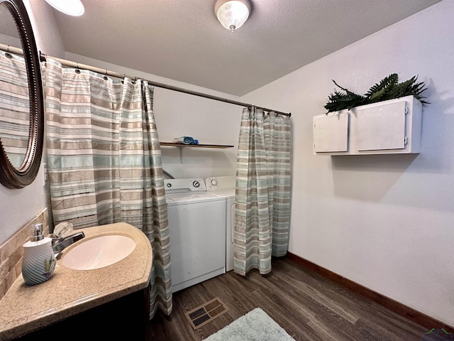 bathroom featuring washing machine and dryer, hardwood / wood-style floors, vanity, and a textured ceiling