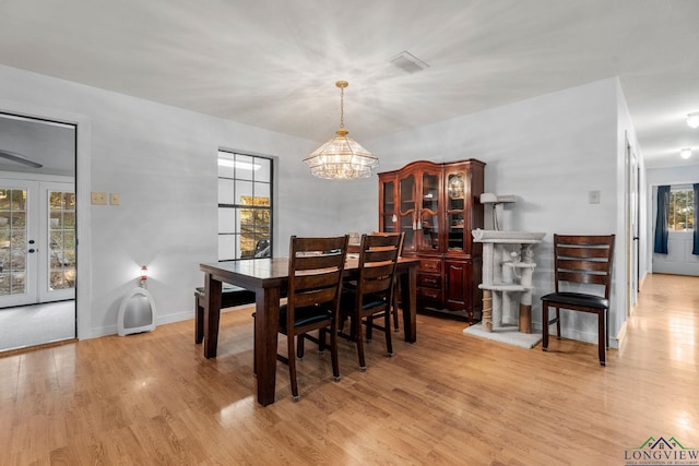 dining room featuring french doors, plenty of natural light, and a notable chandelier