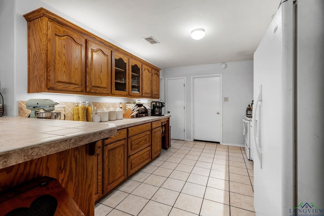 kitchen with white fridge with ice dispenser and light tile patterned floors