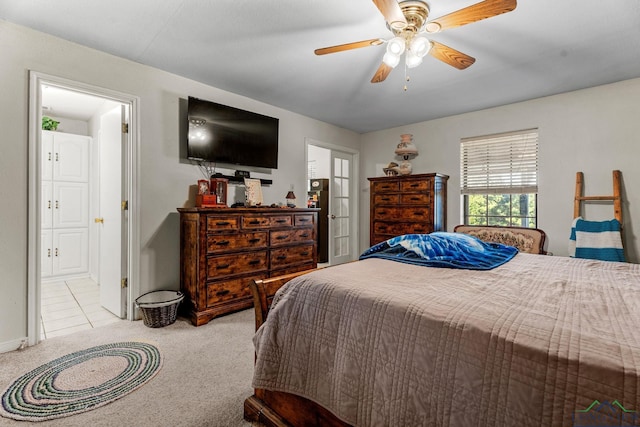 bedroom featuring ceiling fan, ensuite bathroom, and light colored carpet