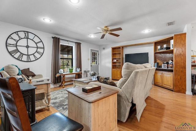 living room featuring ceiling fan and light hardwood / wood-style floors