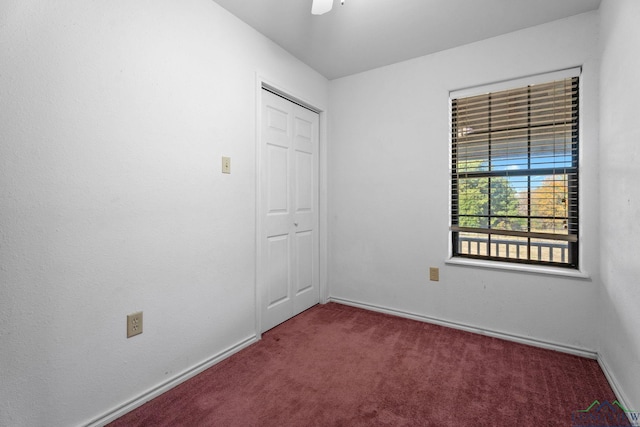 spare room with ceiling fan and dark carpet