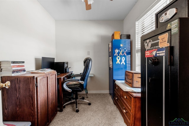 carpeted office space featuring ceiling fan