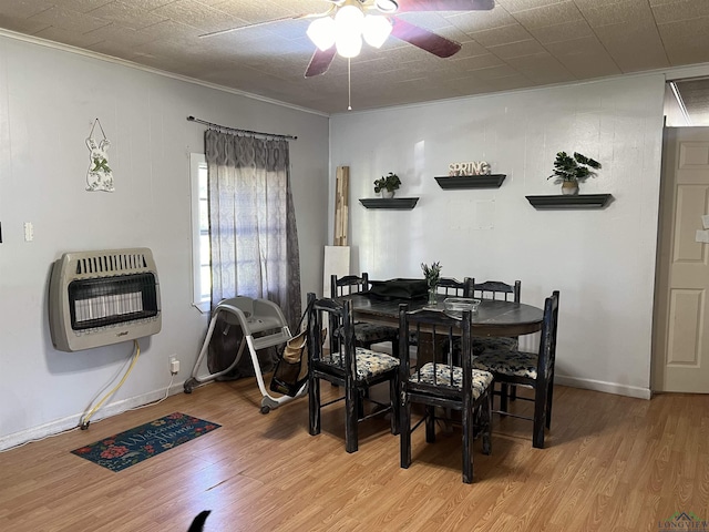 dining space featuring heating unit, ceiling fan, and wood-type flooring