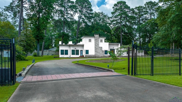 1228 Hillcrest Dr, Longview, TX 75601 - view of front of house featuring stucco siding, a chimney, asphalt driveway, stone siding, and view of scattered trees
