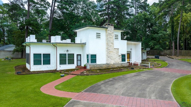 1228 Hillcrest Dr, Longview, TX 75601 - contemporary home featuring driveway, stucco siding, and a chimney
