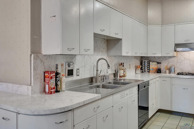 1228 Hillcrest Dr, Longview, TX 75601 - kitchen with dishwashing machine, light countertops, white cabinetry, under cabinet range hood, and light tile patterned flooring
