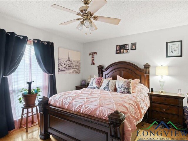 1009 Sequoyah Ln, Longview, TX 75605 - bedroom featuring a textured ceiling, ceiling fan, and light wood-type flooring