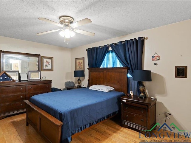 1009 Sequoyah Ln, Longview, TX 75605 - bedroom featuring wood finished floors, a textured ceiling, and a ceiling fan