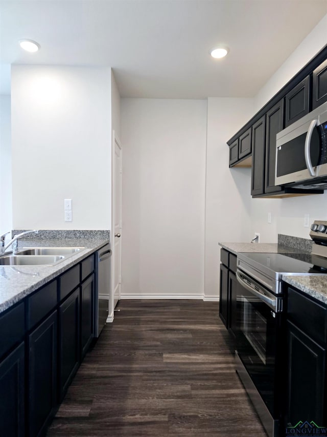 kitchen with stainless steel appliances, dark hardwood / wood-style floors, light stone countertops, and sink