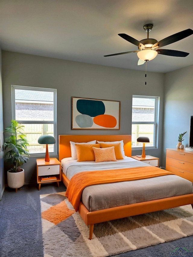 carpeted bedroom featuring multiple windows and ceiling fan