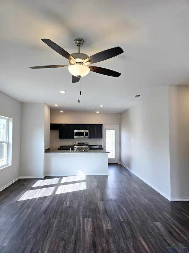 unfurnished living room with ceiling fan and dark hardwood / wood-style floors