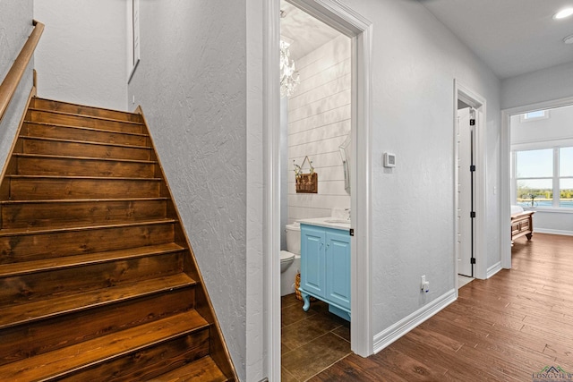 stairs featuring sink and wood-type flooring