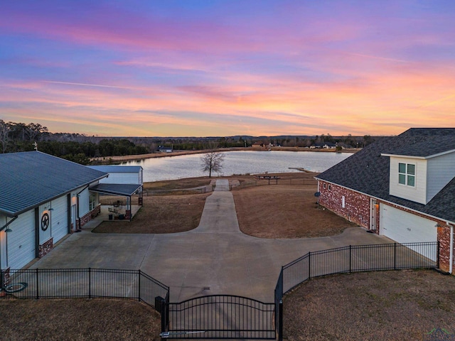 aerial view at dusk featuring a water view