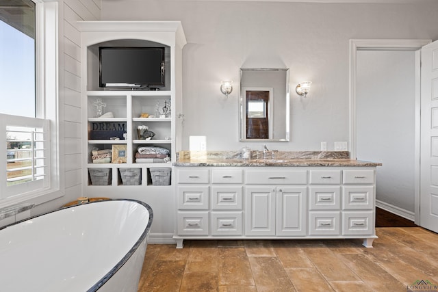 bathroom featuring vanity and a bath