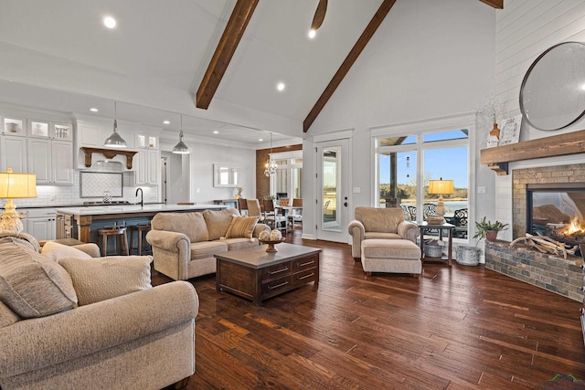 living room featuring dark hardwood / wood-style flooring, a fireplace, high vaulted ceiling, and beamed ceiling