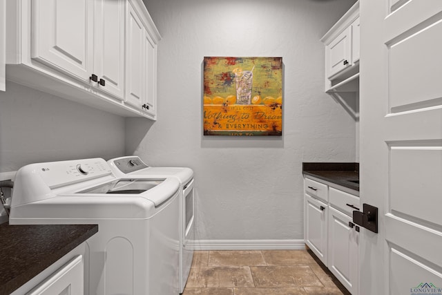 laundry area with cabinets, light tile patterned flooring, and washer and clothes dryer