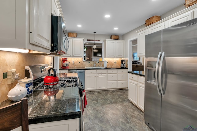 kitchen featuring tasteful backsplash, white cabinetry, sink, and appliances with stainless steel finishes