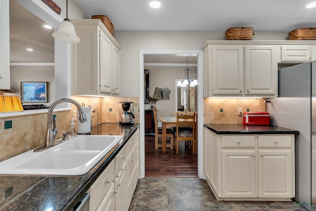 kitchen featuring white cabinetry, sink, a chandelier, decorative light fixtures, and decorative backsplash