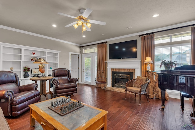 living room with wood-type flooring, plenty of natural light, ceiling fan, and crown molding