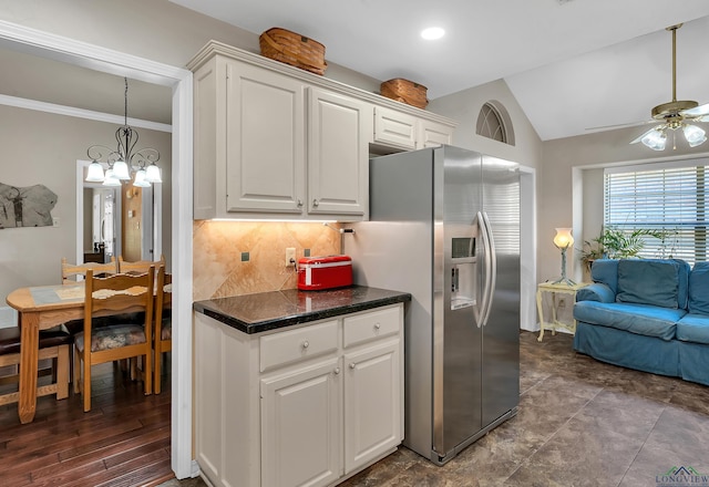 kitchen featuring decorative backsplash, stainless steel fridge, ceiling fan with notable chandelier, vaulted ceiling, and white cabinetry