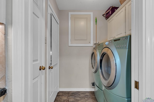 laundry room with cabinets, a textured ceiling, and washing machine and clothes dryer