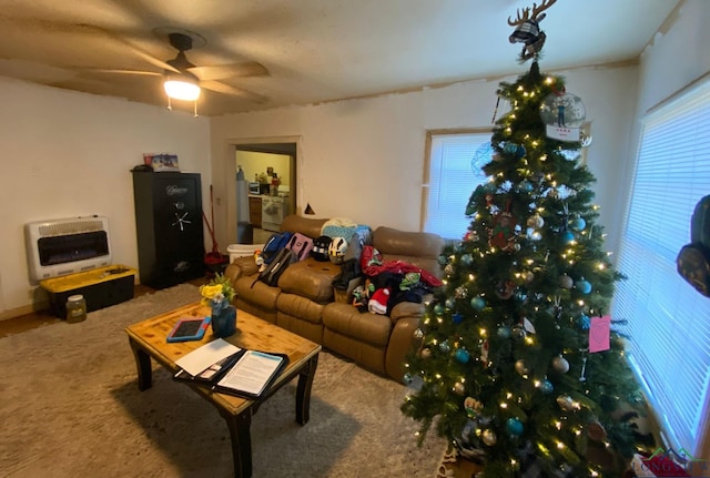 carpeted living room with heating unit and ceiling fan