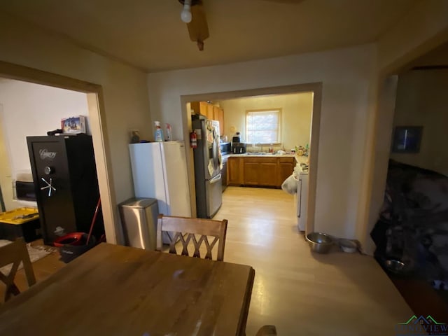 dining area with ceiling fan, light hardwood / wood-style flooring, and sink