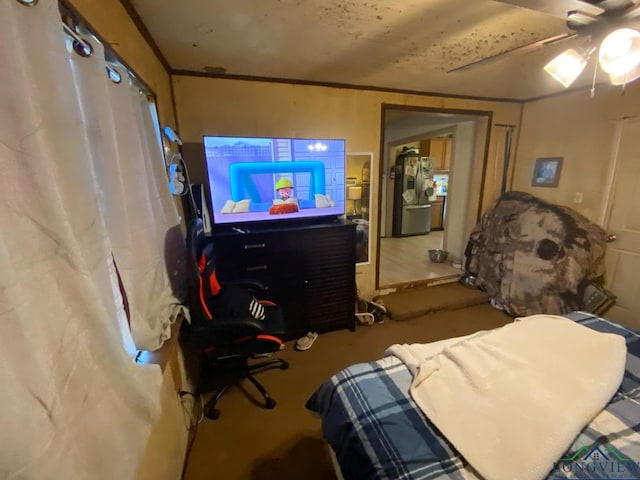 bedroom featuring ceiling fan, ornamental molding, and stainless steel refrigerator with ice dispenser