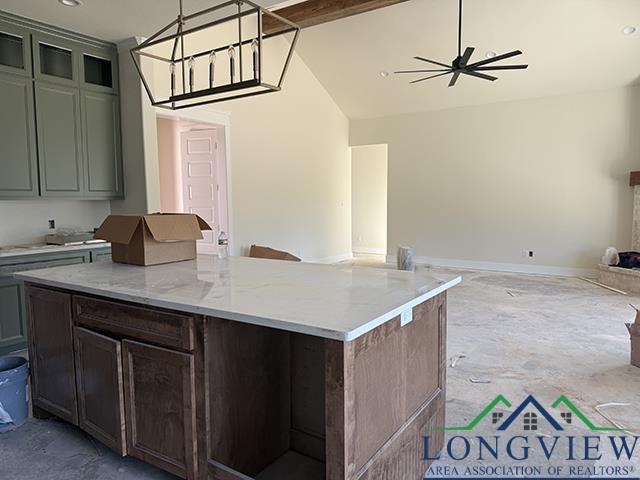 208 Lafoy Ln, Hallsville, TX 75650 - kitchen with open floor plan, ceiling fan, lofted ceiling, a kitchen island, and pendant lighting