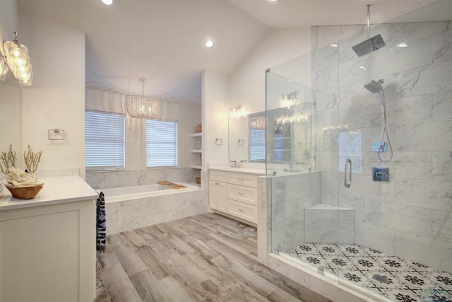 bathroom with a notable chandelier, separate shower and tub, hardwood / wood-style floors, vaulted ceiling, and vanity