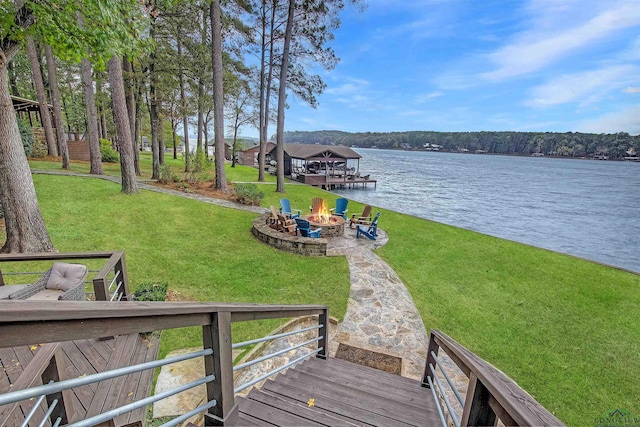 dock area with a lawn, a water view, and an outdoor fire pit