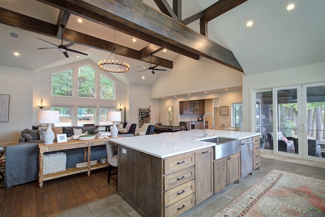 kitchen featuring french doors, sink, a large island with sink, beam ceiling, and high vaulted ceiling