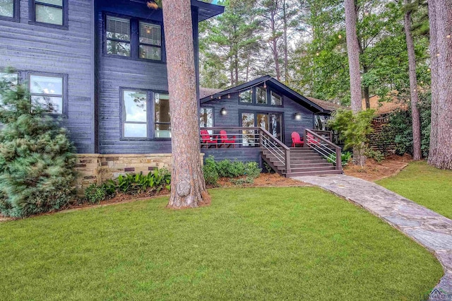 view of front of home with a front yard and a wooden deck