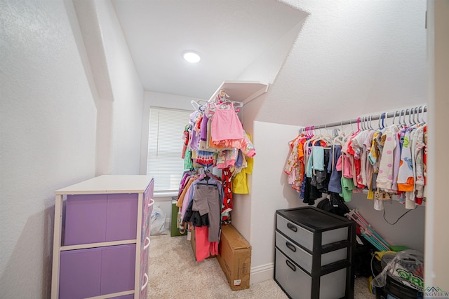 walk in closet featuring light colored carpet