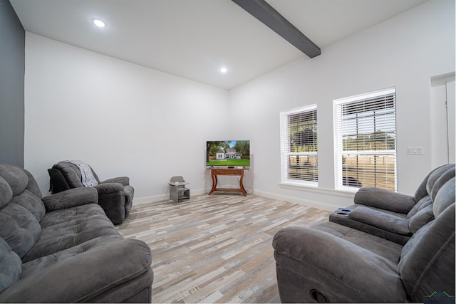 living room featuring beamed ceiling and light hardwood / wood-style flooring