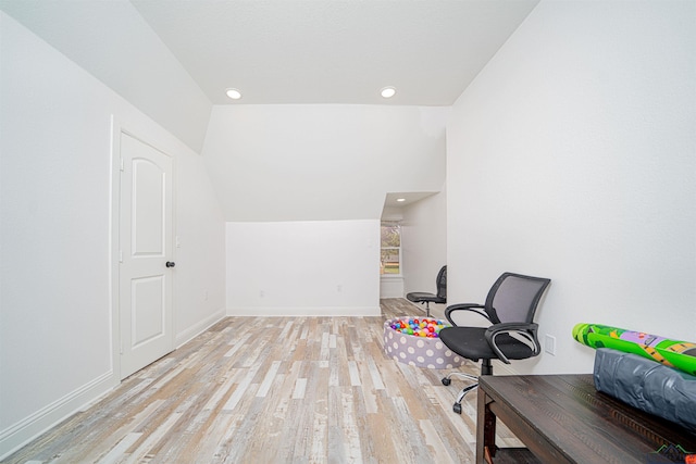 office area with light hardwood / wood-style floors and lofted ceiling