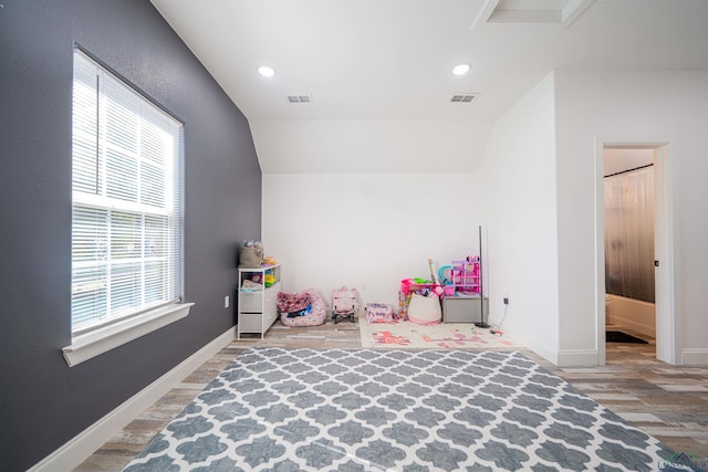 game room featuring a healthy amount of sunlight, lofted ceiling, and hardwood / wood-style floors