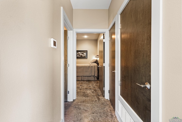 hallway featuring dark carpet